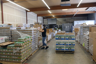 A staffer in the OIC food bank distribution center in Yakima works to fill boxes on April 6. 