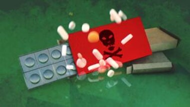 Pills atop a container with a skull and crossbones image on it