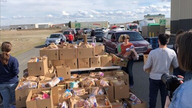 Second harvest volunteers distributing food to cars in drive through format