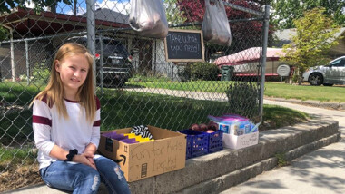 Payge Shows, 9 adds fresh produce to front yard fence to help put community members. 