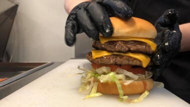 Gloved hands assemble a burger