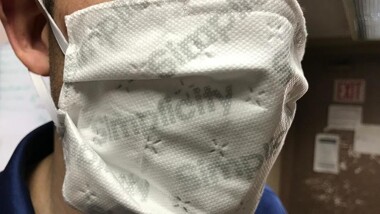 Person wearing a face mask with the word simplicity printed on it