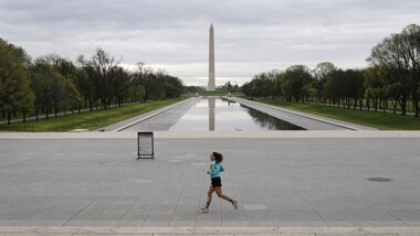 Woman running alone with washington monument in the background