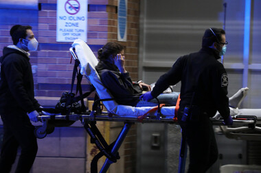 Medical workers take a patient on a stretcher inside a coronavirus intake area at Maimonides Medical Center in Brooklyn, New York.