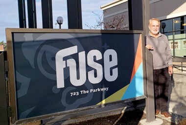 Man standing beside FUSE sign