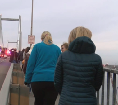 line of people walking across the cable bridge