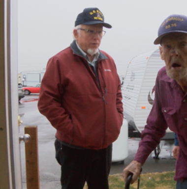 veteran walking into new home while another man watches