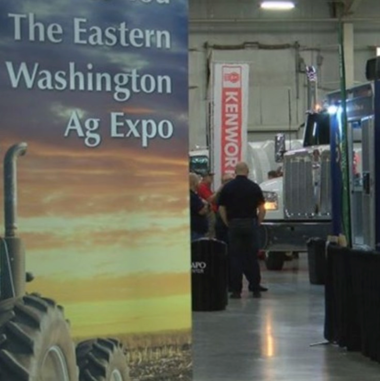Ag expo sign with man standing in front of booth in the distance