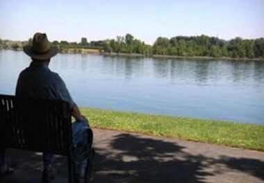 person in a farmers hat sitting on a bench