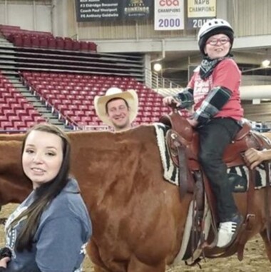 Rascal Rodeo volunteers with a kid riding a horse