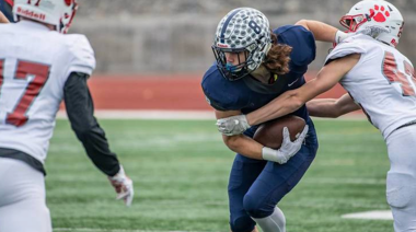 Football player running the ball and breaking a tackle