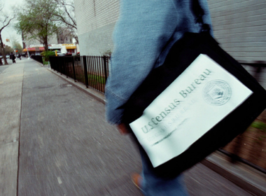 person walking with bag that says census bureau on it