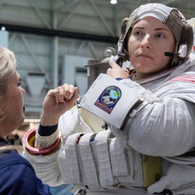 female astronaut pulling off her helmet