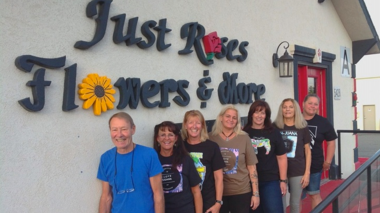 workers at just roses flowers and more posing in front of the building