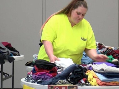 woman organizing piles of clothes