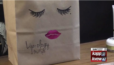 paper bag with lips and eyelashes drawn onto it