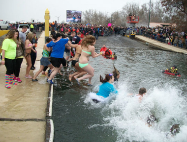 Large crowd of people jumping into river