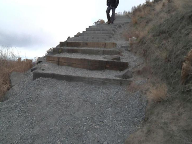 Wooden stairs outdoors with gravel trail