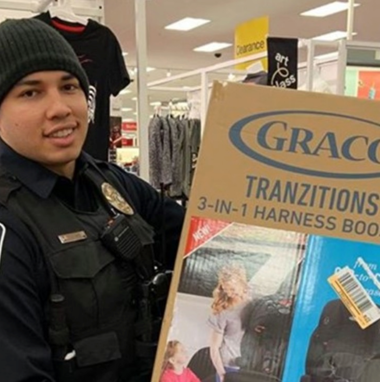 Police officer holding a car seat in its box