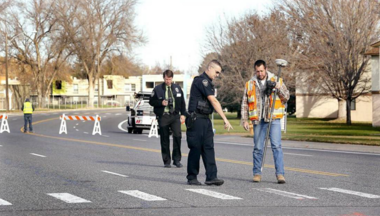 cop and construction worker examin sidewalk
