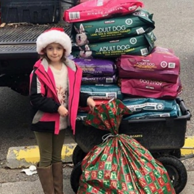 Little girl next to piles of animal food