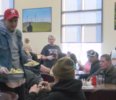 People eating thanksgiving meals at long tables