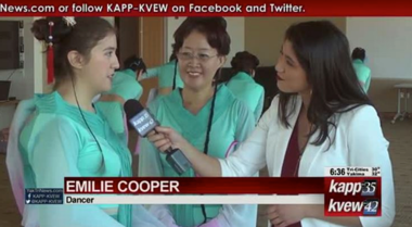 Two women in matching turqoise dresses being interviewed