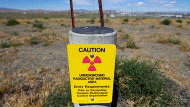 cement cylindrical container with a yellow radiation hazard warning sign on it