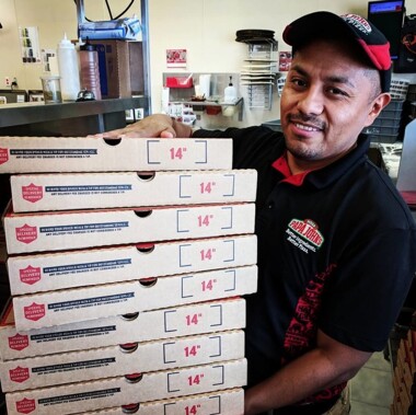 Papa John's employee holding pizza boxes