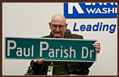 Paul Parish holding street sign bearing his name