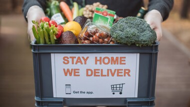 Basket of vegetables with a sign on it that says stay home we deliver