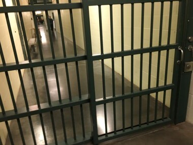 Locked, bar doors in a jail hallway