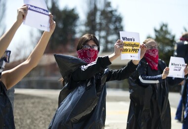 Giselle Uribe-Sayah, 15, wears a garbage bag and handkerchief while joining a nationwide protest demanding PPE for healthcare workers on April 9, 2020, outside of Evergreen Health in Monroe.