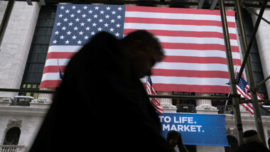 Silhouete of a person walking close up with an American flag in the background